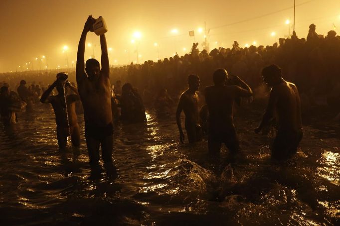 Hindu devotees pray as they attend the first 'Shahi Snan' (grand bath) at the ongoing "Kumbh Mela", or Pitcher Festival, in the northern Indian city of Allahabad January 14, 2013. During the festival, Hindus take part in a religious gathering on the banks of the river Ganges. "Kumbh Mela" will return again to Allahabad in 12 years. REUTERS/Ahmad Masood (INDIA - Tags: RELIGION SOCIETY) Published: Led. 14, 2013, 7:34 dop.