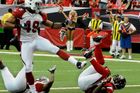 Roddy White (vpravo) z celku Atlanta Falcons letí k zemi pro touchdown, obrana týmu Arizona Cardinals (Rashad Johnson - vlevo) se jej marně snaží zastavit. Hráč na středu vlevo je cornerback Kardinálů Dominique Rodgers-Cromartie.  