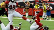 Roddy White (vpravo) z celku Atlanta Falcons letí k zemi pro touchdown, obrana týmu Arizona Cardinals (Rashad Johnson - vlevo) se jej marně snaží zastavit. Hráč na středu vlevo je cornerback Kardinálů Dominique Rodgers-Cromartie.  