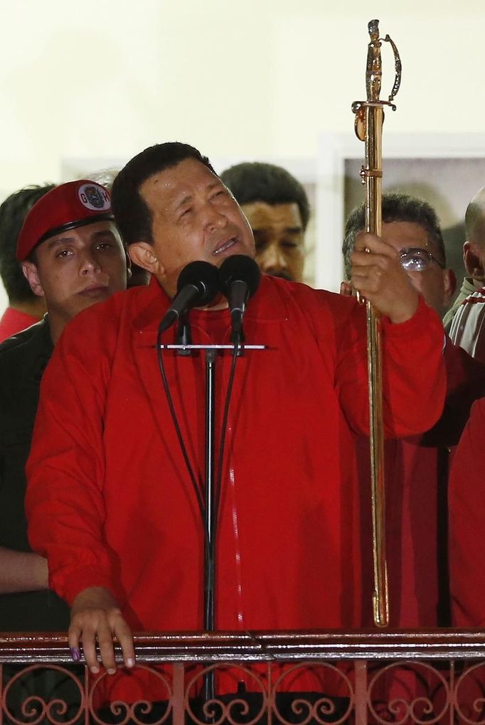 President Hugo Chavez holds the sword used by former Venezuelan military leader Simon Bolivar while celebrating from a balcony at Miraflores Palace in Caracas October 7, 2012. Venezuela's socialist President Chavez won re-election in Sunday's vote with 54 percent of the ballot to beat opposition challenger Henrique Capriles. REUTERS/Jorge Silva (VENEZUELA - Tags: POLITICS ELECTIONS) Published: Říj. 8, 2012, 4:58 dop.