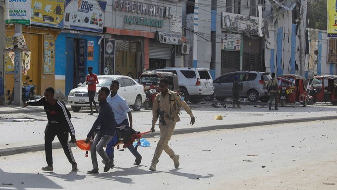 Lidé odnášejí zraněného z místa exploze poblíž ministerstva školství v Mogadišu.