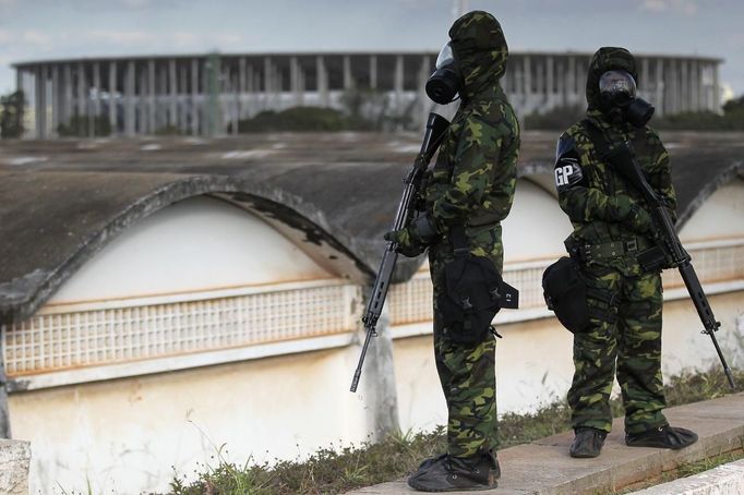 Brazilian army soldiers wearing chemical suits participate in an anti-terror simulation exercise as part of the preparation for the upcoming 2013 FIFA Confederations Cup in Brasilia. May 22, 2013. About 100 soldiers took part in the exercise which include preventive strikes against chemical, biological and radiological weapons conducted around Mane Garrincha National Stadium, according to an official statement. REUTERS/Ueslei Marcelino (BRAZIL - Tags: SPORT SOCCER MILITARY) Published: Kvě. 22, 2013, 9:45 odp.