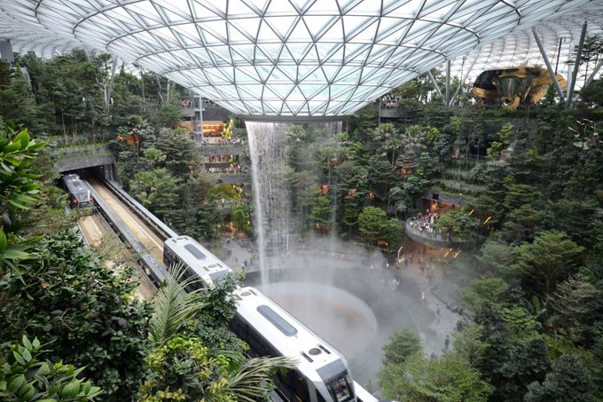 K letištní hale se cestující dostanou pomocí vlaků, které projíždí okolo gigantického vodopádu.