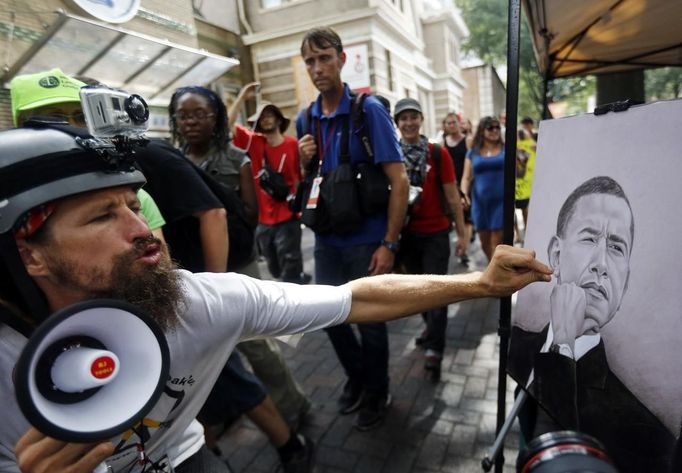 A demonstrator mocks a portrait of President Barack Obama while marching during a protest during the first day of the Democratic National Convention in Charlotte, North Carolina September 4, 2012. REUTERS/John Adkisson (UNITED STATES - Tags: POLITICS CIVIL UNREST) Published: Zář. 4, 2012, 9:07 odp.