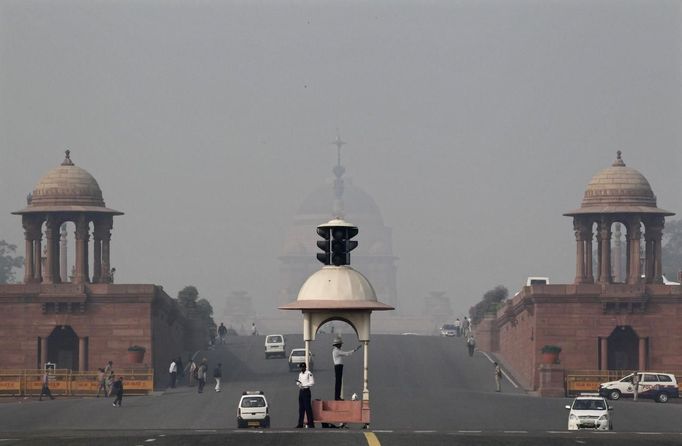 A traffic police officer directs traffic in front of India's presidential palace Rashtrapati Bhavan amid dense smog in New Delhi November 14, 2012. Indians are at high risk of respiratory ailments, heart disease and lung cancer, according to World Health Organization (WHO) data that showed Delhi's air had almost 10 times the recommended level of PM10 particulate matter, or particles small enough to penetrate to the deepest part of the lungs and cause health problems. REUTERS/B Mathur (INDIA - Tags: ENVIRONMENT SOCIETY HEALTH) Published: Lis. 14, 2012, 6:38 dop.