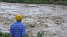 A man watches heavy rains from Hurricane Sandy cause the Croix de Mission river to swell to levels that threaten to flood the homes along its bank and nearby areas, in Port-au-Prince October 25, 2012. According to media reports Hurricane Sandy has claimed one life in Haiti. REUTERS/Swoan Parker (HAITI - Tags: DISASTER ENVIRONMENT) Published: Říj. 25, 2012, 11:32 odp.