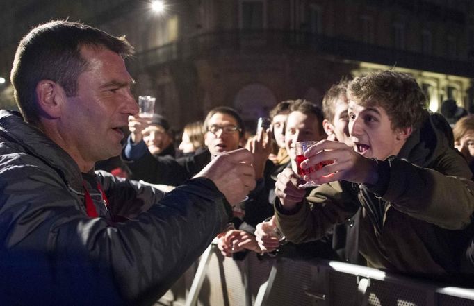 A staff member (L) gestures to a man during the official launch of the 2012 Beaujolais Nouveau wine in the center of Lyon early November 15, 2012. REUTERS/Robert Pratta (FRANCE - Tags: SOCIETY) Published: Lis. 15, 2012, 2:38 dop.