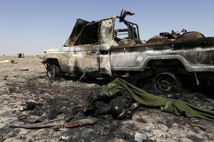 ATTENTION EDITORS - VISUAL COVERAGE OF SCENES OF INJURY OR DEATH The charred body of an Islamist rebel is seen near a destroyed vehicle on the road between Diabaly and Timbuktu in Mali January 30, 2013. REUTERS/Benoit Tessier (MALI - Tags: POLITICS CONFLICT) TEMPLATE OUT Published: Led. 30, 2013, 9:38 odp.