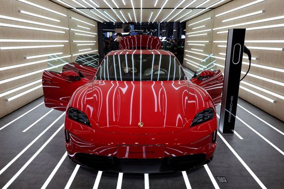 FILE PHOTO: People look at the Porsche Taycan GTS electric vehicle (EV) during a media day for the Auto Shanghai show in Shanghai, China April 23, 2025. REUTERS/Go Nakamu