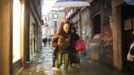 People walk in a flooded street during a period of seasonal high water in Venice November 11, 2012. The water level in the canal city rose to 149 cm (59 inches) above normal, according to local monitoring institute Center Weather Warnings and Tides. REUTERS/Manuel Silvestri (ITALY - Tags: ENVIRONMENT SOCIETY) Published: Lis. 11, 2012, 1:56 odp.