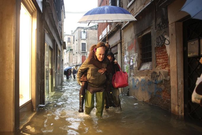 People walk in a flooded street during a period of seasonal high water in Venice November 11, 2012. The water level in the canal city rose to 149 cm (59 inches) above normal, according to local monitoring institute Center Weather Warnings and Tides. REUTERS/Manuel Silvestri (ITALY - Tags: ENVIRONMENT SOCIETY) Published: Lis. 11, 2012, 1:56 odp.