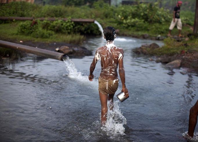 A worker covered with soap walks to take a bath after working at an open cast coal field at Dhanbad district in the eastern Indian state of Jharkhand September 20, 2012. With oil and gas output disappointing and hydropower at full throttle, Asia's third-largest economy still relies on coal for most of its vast energy needs. About 75 percent of India's coal demand is met by domestic production and, according to government plans, that won't change over the next five years. Picture taken September 20, 2012. To match INDIA-COAL/ REUTERS/Ahmad Masood (INDIA - Tags: BUSINESS EMPLOYMENT ENERGY SOCIETY ENVIRONMENT) Published: Říj. 21, 2012, 10:04 odp.