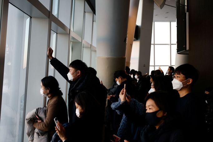 Lidé pozorují západ Slunce před oslavami Nového roku z observatoře v jihokorejském Soulu.