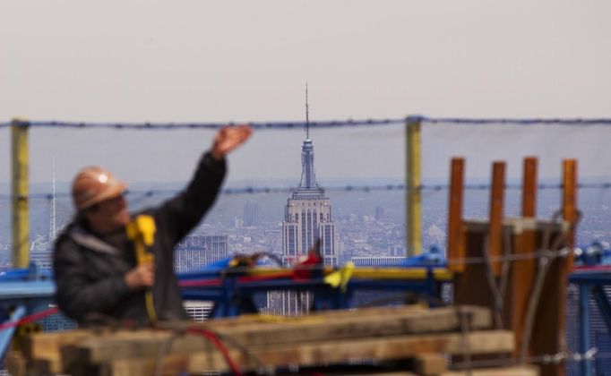 The Empire State Building is seen behind an iron worker as he stands next to protective netting on the 100th story of One World Trade Center in New York, April 30, 2012. The addition of iron columns to the 100th story pushed the height of One World Trade above that of the Empire State Building today. REUTERS/Lucas Jackson (UNITED STATES - Tags: CITYSPACE SOCIETY) Published: Dub. 30, 2012, 11:46 odp.