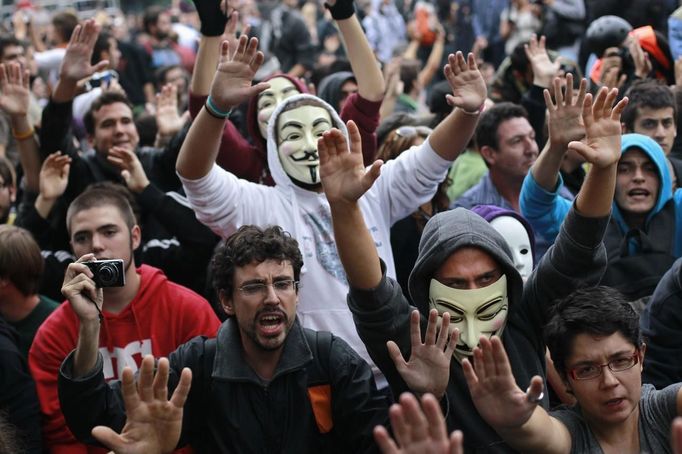 Demonstrators sing "These are our weapons" as they hold their hands up after riot police charged them outside the Spanish parliament in Madrid, September 25, 2012. Protesters clashed with police in Spain's capital on Tuesday as the government prepares a new round of unpopular austerity measures for the 2013 budget that will be announced on Thursday. REUTERS/Susana Vera (SPAIN - Tags: CIVIL UNREST BUSINESS POLITICS) Published: Zář. 25, 2012, 9:35 odp.