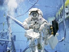 Astronauté trénují opravu Hubbleova teleskopu v bazénu.