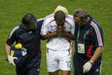 Francouzký útočník Thierry Henry opuští trávník v doporovdu lékaře a maséra.