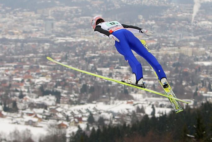 Rakušan Martin Koch letí nad městem Liberec při zkušebním skoku před soutěží družstev.