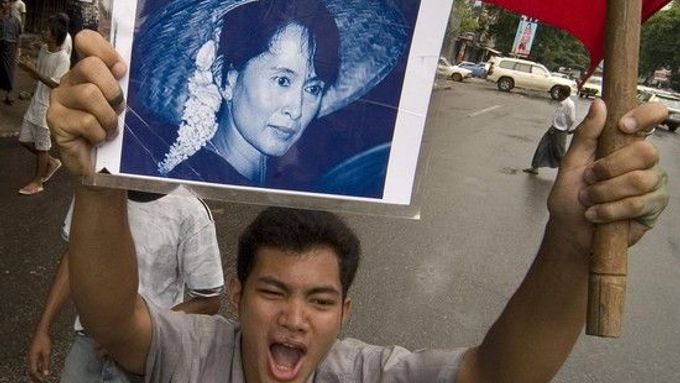 Muž při demonstraci ukazuje portrét nejznámější disidentky Aun Schan Su Ťij.