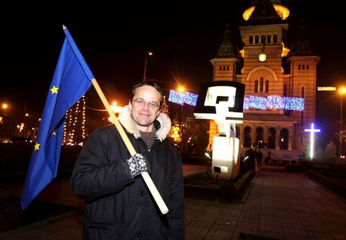 Na opačném konci Náměstí Vítězství stojí Metropolitní katedrála. Tady, na schodech katedrály, postříleli na demonstraci 18. prosince 1989 četníci skupinu dětí. Touto událostí eskalovala rumunská revoluce započatá v Temešváru o několik dní dříve. Teodor Ciomocos (na snímku) si jako jeden z mála včera přinesl na náměstí vlajku Evropské unie.