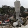 A propeller from an Indonesian military C-130 Hercules transport plane rests on the roof of a building after the plane crashed into a residential area in the North Sumatra city of Medan, Indonesia