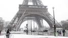 A man rides bicycle as he makes his way along a snow-covered sidewalk near the Eiffel Tower in Paris March 12, 2013 as winter weather with snow and freezing temperatures returns to northern France. REUTERS/John Schults (FRANCE - Tags: ENVIRONMENT CITYSPACE) Published: Bře. 12, 2013, 3:19 odp.