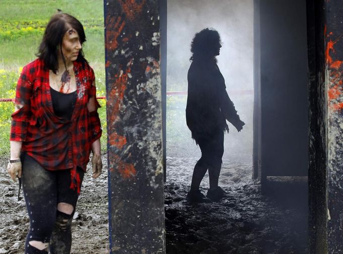 Zombies wait to chase runners at the "Run for Your Lives" 5K obstacle course race in Amesbury, Massachusetts May 5, 2012. Runners face man-made and natural obstacles on the course, while being chased by zombies, who try to take "health" flags off the runners belts. REUTERS/Brian Snyder (UNITED STATES - Tags: SPORT SOCIETY TPX IMAGES OF THE DAY) Published: Kvě. 5, 2012, 8:16 odp.