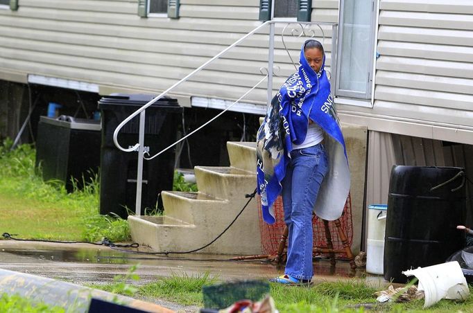 A woman shields herself from the rain as outer bands of Hurricane Isaac head towards the Louisiana coast line in Happy Jack, Louisiana August 28, 2012. Tropical Storm Isaac closed in on the U.S. Gulf Coast on Tuesday and was expected to make landfall as a full-blown hurricane in the New Orleans area seven years after the city was devastated by Hurricane Katrina. REUTERS/Sean Gardner (UNITED STATES - Tags: ENVIRONMENT DISASTER) Published: Srp. 28, 2012, 4:48 odp.