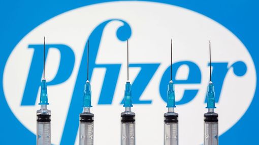 Injekční stříkačky a logo farmaceutické společnosti Pfizer, která společně s firmou BioNTech vytvořila vakcínu proti koronaviru.