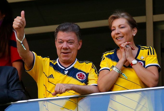 Colombia's President Juan Manuel Santos gestures next to his wife Maria Clemencia during the team's 2014 World Cup Group C soccer match against Ivory Coast at the Brasili