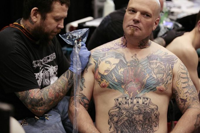 A tattoo artist works on the shoulder of a client at the Hampton Roads Tattoo Festival in Virginia March 3, 2012. The hobby of collecting tattoos has exploded into the mainstream in society with tattoo conventions and festivals held year-round across the United States and the world. Picture taken March 3, 2012. REUTERS/Larry Downing (UNITED STATES - Tags: SOCIETY) ATTENTION EDITORS PICTURE 09 OF 31 FOR PACKAGE 'ADDICTED TO THE NEEDLE' TO FIND ALL PICTURES SEARCH 'ADDICTED NEEDLE' Published: Čer. 29, 2012, 12:59 odp.