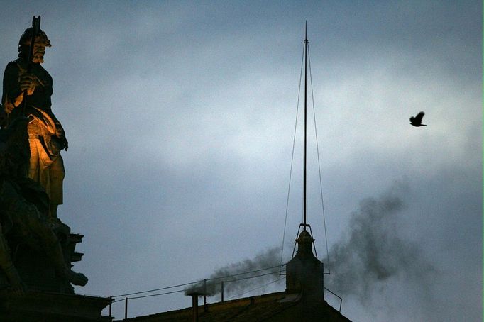 Black smoke rises from the chinmey of the Sistine Chapel meaning that cardinals failed to elect a new pope in the first ballot of their secret conclave 18 April 2005 at the Vatican City. More than 10,000 people watching from Saint Peter's Square initially broke into ecstatic applause, thinking the election had been successful because the first puffs of smoke appeared white, before the narrow chimney atop the chapel began billowing black fumes. AFP PHOTO FILIPPO MONTEFORTE