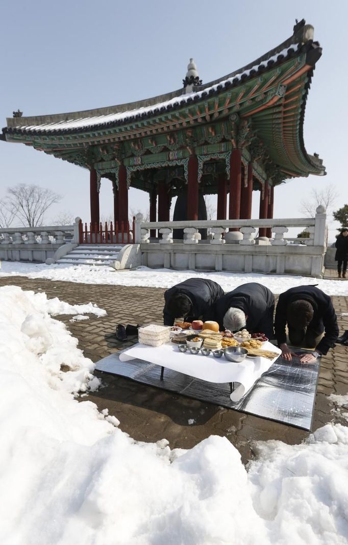 ¨ South Korean Lee Dong-woon (2nd R), 84, who was originally from North Korea's Songhwa in Hwanghae Province, bows with his son and grandson (R) in the direction of the North during a memorial service for ancestors near the demilitarized zone separating the two Koreas, in Paju, 55 km (34 miles) north of Seoul February 10, 2013, on the occasion of Seolnal, the Korean Lunar New Year's day. Lee has not been able to visit his hometown since the 1950-53 Korean War. REUTERS/Lee Jae-Won (SOUTH KOREA - Tags: MILITARY POLITICS SOCIETY) Published: Úno. 10, 2013, 6 dop.