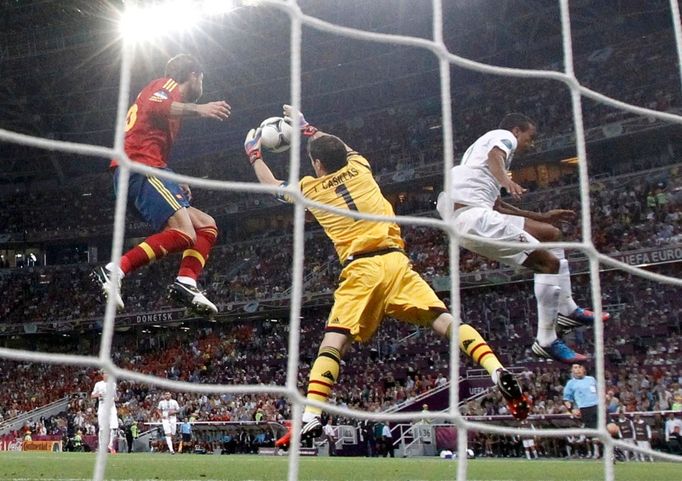 Iker Casillas chytá střelu Andrése Iniesty a asistuje mu Nani během semifinále na Euru 2012.