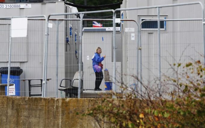 A woman mops outside temporary accommodation for workers of the London 2012 Olympic Park at Stratford in London July 17, 2012. REUTERS/Luke MacGregor (BRITAIN - Tags: SPORT OLYMPICS BUSINESS EMPLOYMENT) Published: Čec. 17, 2012, 6:43 odp.