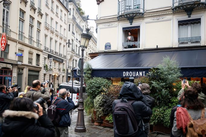 Brigitte Giraudová mává novinářům z okna pařížské restaurace Drouant.