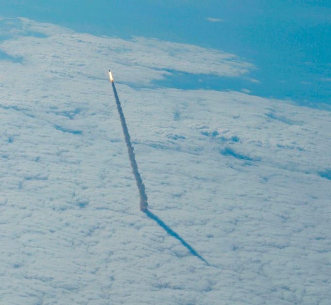 Překrásný záběr z 20. května ukazuje raketoplán Endeavour po startu při průniku mraky.