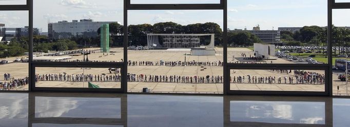 People line up in front of Planalto Palace to attend the funeral of Oscar Niemeyer in Brasilia December 6, 2012. Niemeyer, a towering patriarch of modern architecture who shaped the look of modern Brazil and whose inventive, curved designs left their mark on cities worldwide, died late on Wednesday. He was 104. Niemeyer had been battling kidney and stomach ailments in a Rio de Janeiro hospital since early November. His death was the result of a lung infection developed this week, the hospital said, little more than a week before he would have turned . REUTERS/Paulo Whitaker (BRAZIL - Tags: SOCIETY OBITUARY) Published: Pro. 6, 2012, 8:30 odp.