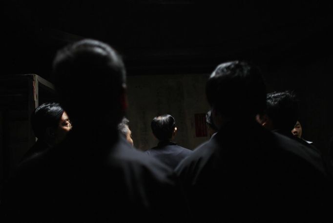 Mid-level government officials stand inside an old house where former Chinese leader Mao Zedong used to live, during a five-day training course at the communist party school called China Executive Leadership Academy of Jinggangshan, in Jiangxi province, in this September 21, 2012 file photo. China's Communist Party has dramatically stepped up its training of the country's roughly 40 million party and government officials in the past decade. With public scrutiny of cadre behaviour growing via social media, the party is likely to call for continued, and deepened, cadre education at the upcoming 18th Party Congress. At the vanguard of this education drive, alongside a Central Party School in Beijing, are three "Executive Leadership Academies" which opened in 2005 for middle-ranking and senior officials in Shanghai, Yan'an and Jinggangshan. The curriculum covers Marxism, Leninism and Mao Zedong Thought, but students may also take finance courses, receive in-depth media training or role-play crisis management scenarios on everything from disease outbreaks to train wrecks. REUTERS/Carlos Barria/Files (CHINA - Tags: POLITICS SOCIETY) Published: Zář. 24, 2012, 1:53 odp.