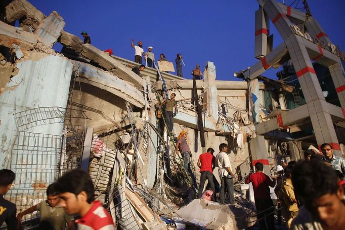 Rescue workers try to rescue trapped garment workers in the Rana Plaza building which collapsed, in Savar, 30 km (19 miles) outside Dhaka April 24, 2013. A block housing garment factories and shops collapsed in Bangladesh on Wednesday, killing nearly 100 people and injuring more than a thousand, officials said. REUTERS/Andrew Biraj (BANGLADESH - Tags: DISASTER BUSINESS TPX IMAGES OF THE DAY) Published: Dub. 24, 2013, 4:17 odp.