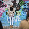 Lennonova zeď po třech měsících od malování - turisté, graffiti