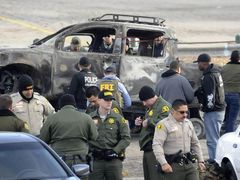 Policisté u auta, které na útěku zapálil jejich bývalý kolega Christopher Dorner. Ohořelý vrak našli v městečku Big Bear Lake na jihu Kalifornie.