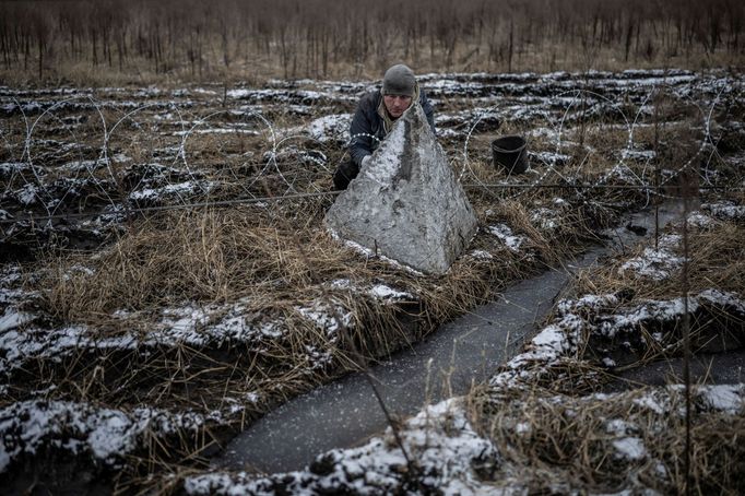 A worker installs razor wire as a part of defence structures near a front line, amid Russia's attack on Ukraine, in the Kharkiv region, Ukraine December 25, 2023. REUTERS