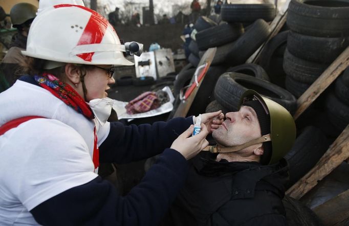 A medic cleans the eyes of an anti-government protester as he mans a barricade in Kiev February 21, 2014.