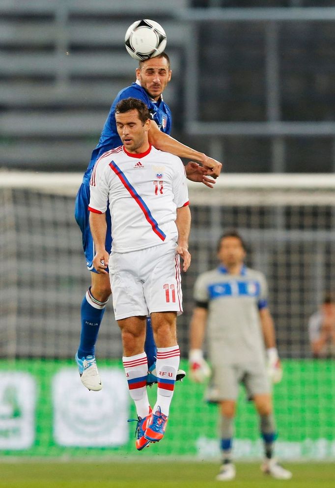 Leonardo Bonucci v hlavičkovém souboji s Alexandrem Keržakovem během přípravného utkání na Euro 2012.