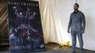 Magician David Blaine stands near a poster promoting his upcoming performance "Electrified" during a press briefing in New York, October 2, 2012. During the performance Blaine will wear a custom made metal suit and will stand on a 20-foot-high (6 meter) platform on New York City's Pier 54 on the edge of the Hudson River while surrounded by seven metallic orbs, or tesla coils, that will stream 1 million volts of electricity around him for 3 days and nights. REUTERS/Mike Segar (UNITED STATES - Tags: ENTERTAINMENT SOCIETY) Published: Říj. 2, 2012, 7:06 odp.