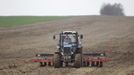 A villager operating a tractor sows barley at the village of Novosyolki