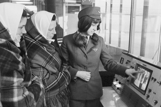 Dozorčí  turniketů v metru ukazuje družstevnicím z Břeclavska monitorovací systém. 1975