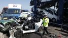 A police officer reacts as he stands amongst the wreckage of some of the 100 vehicles involved in multiple collisions, which took place in dense fog during the morning rush hour, on the Sheppey Bridge in Kent, east of London, September 5, 2013. Eight people were seriously injured and dozens hurt in the multiple crashes.