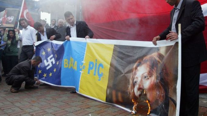 Pravicoví protestanti pálí plakát s portrétem Elif Šafakové před istanbulským soudem.